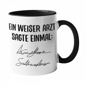 Weiße Keramiktasse mit schwarzem Henkel und schwarzer Innenseite, bedruckt mit „Ein weiser Arzt sagte einmal:“ und zwei unleserlichen Kritzel-Unterschriften.
